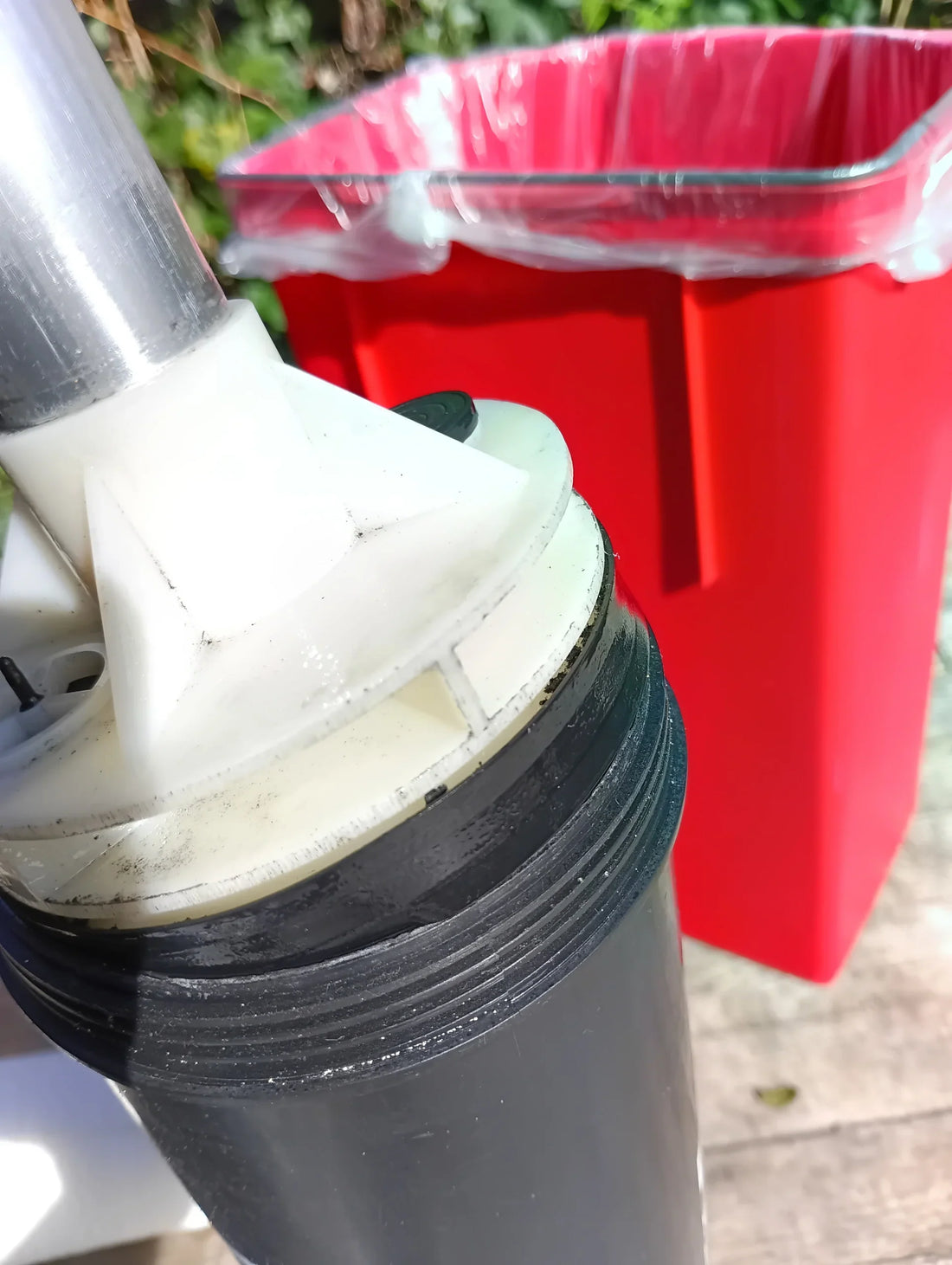 A kite pump with the top cap off exposing the piston and valves